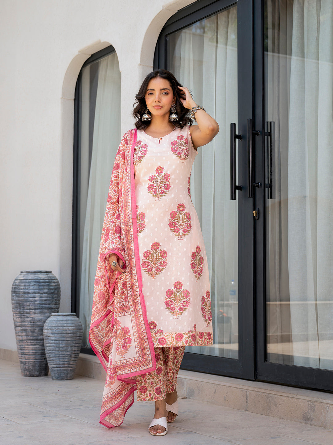 Woman in a pink floral printed cotton kurta pant set with white floral patterns