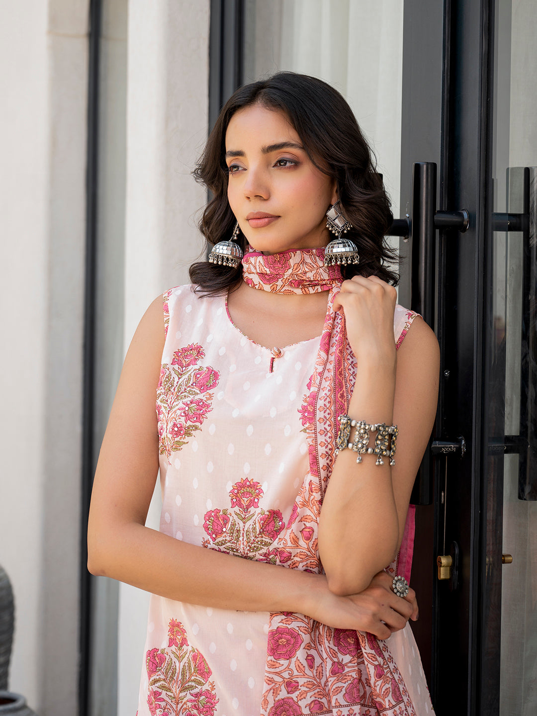 Woman in a Pink Floral Printed Cotton Kurta Pant Set with ornate silver jewelry