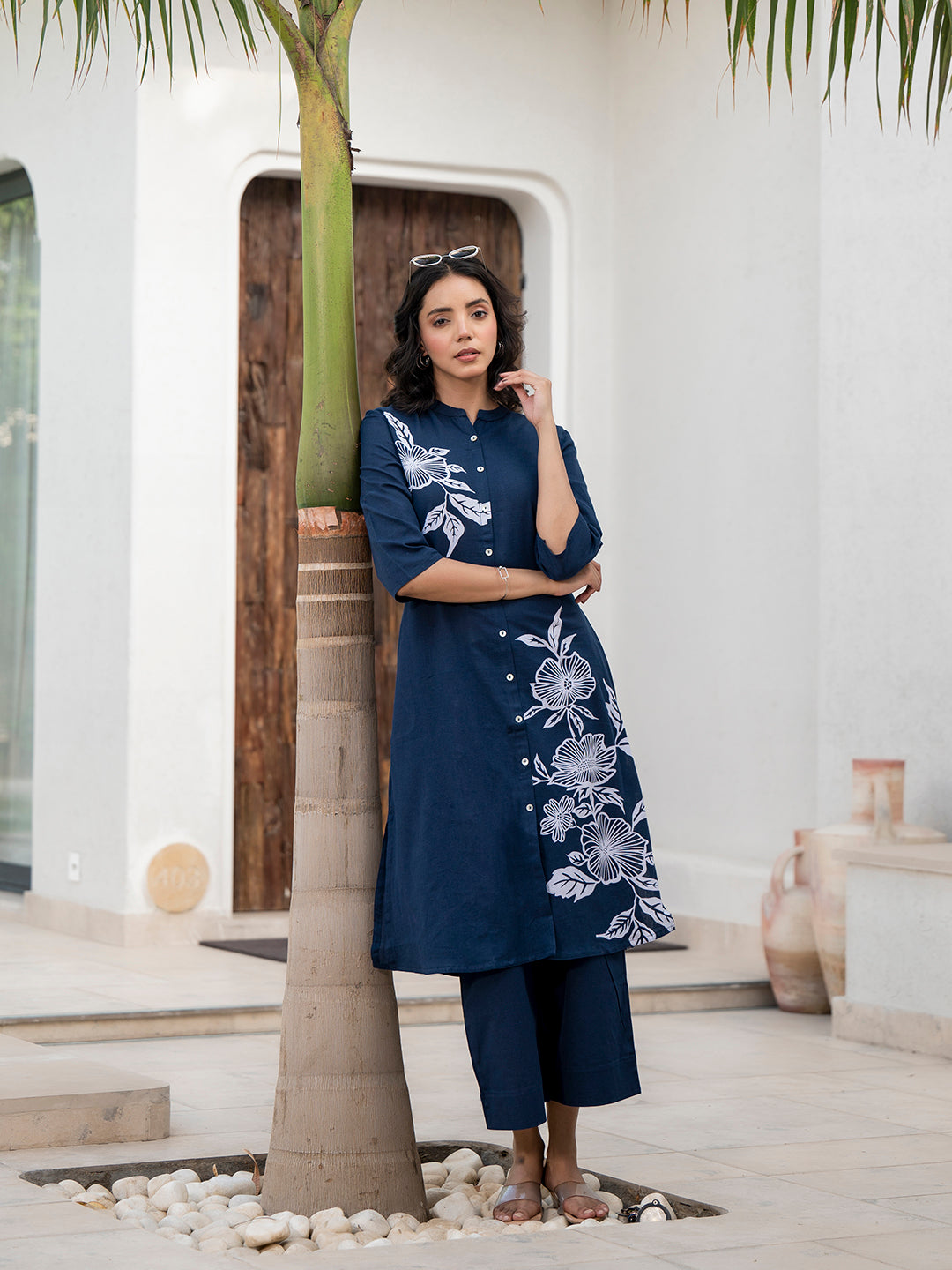 Woman in navy blue floral printed cotton dress near a palm tree showcasing kurta pant set