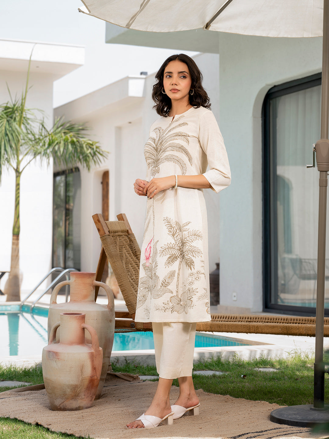 Woman in cream floral printed cotton A-line fit kurta pant set amid greenery