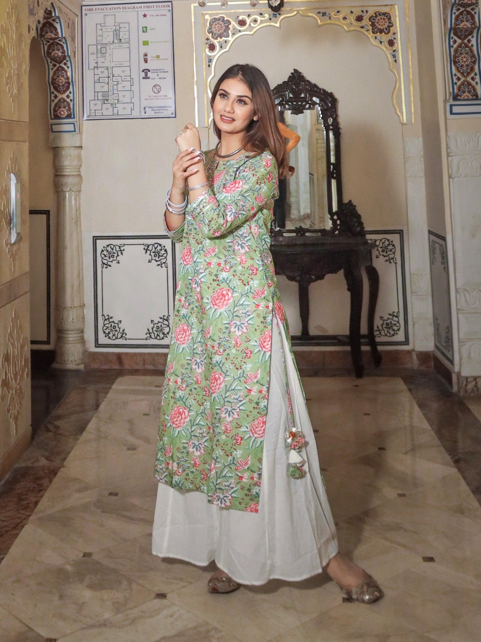 Woman in a floral green printed cotton kurta with palazo set taking a selfie