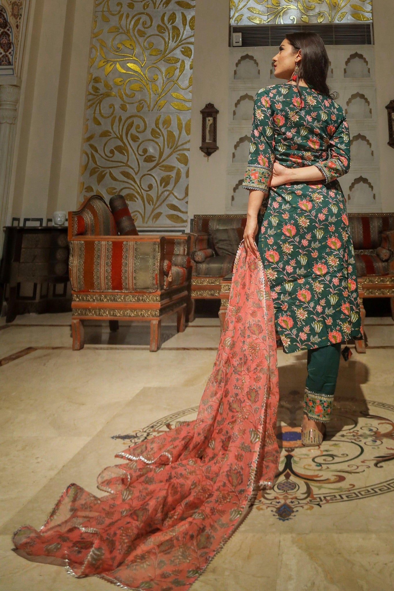 Woman in a green floral printed kurta pant set with a pink embroidered shawl