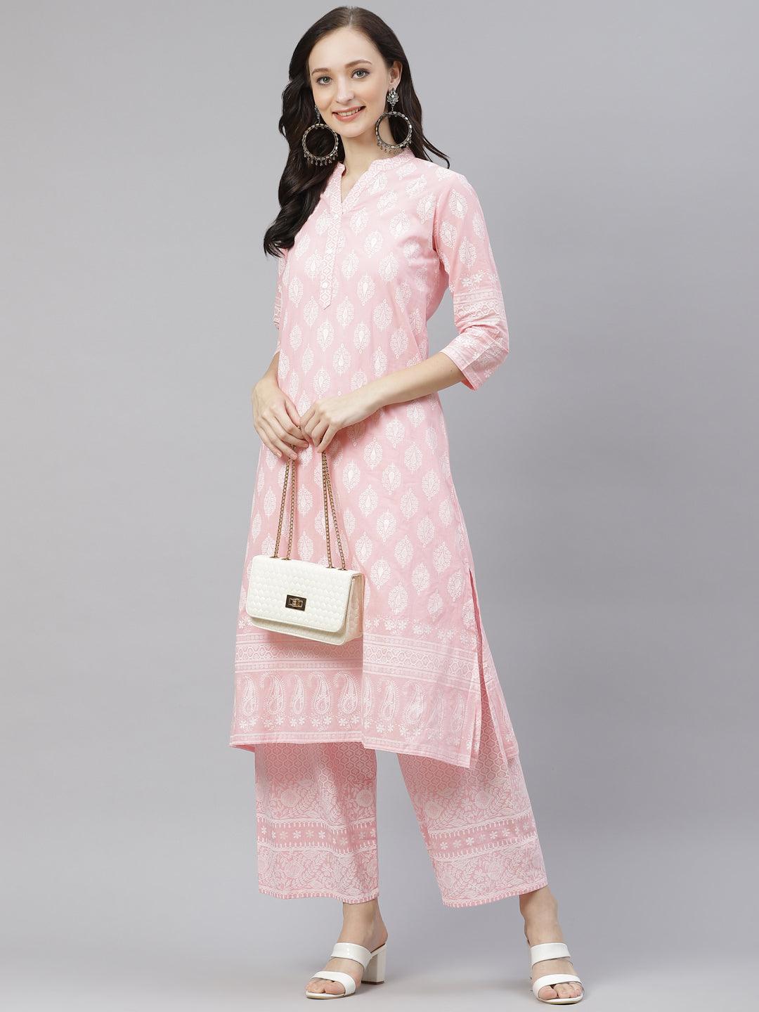 Woman wearing a pale pink traditional Indian kurta and palazzo pants set with a white handbag.