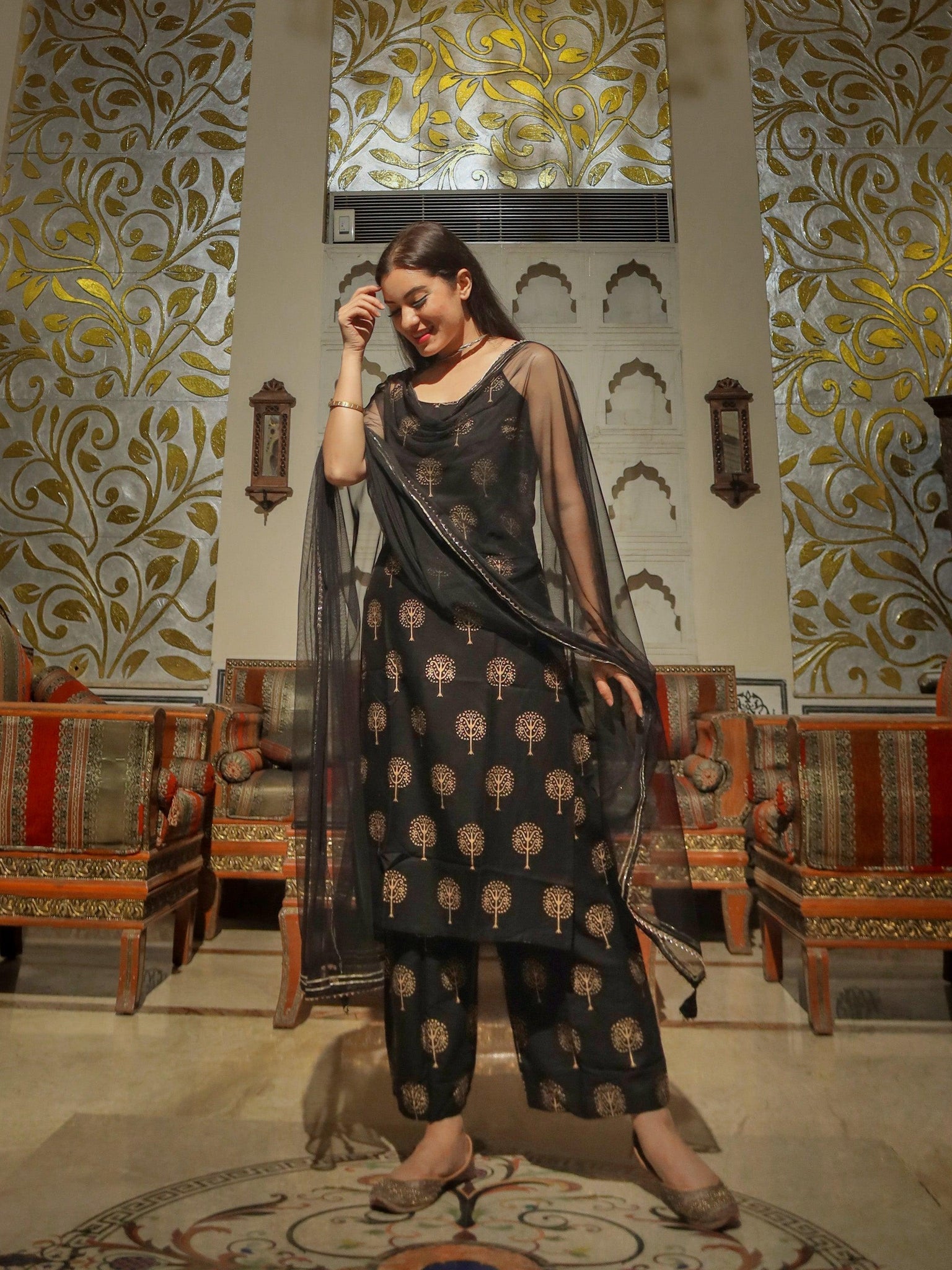 Woman in an elegant Black Golden Foil Printed Shoulder Strip Kurta Palazoo Set