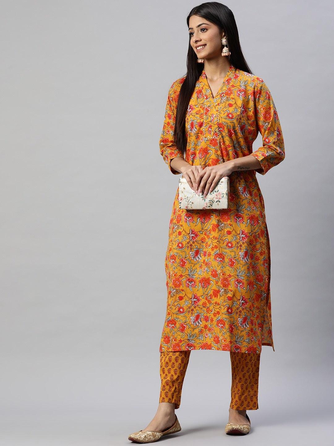 Woman modeling a Mustard Cotton Floral Printed Kurta Pant Set with vibrant floral patterns