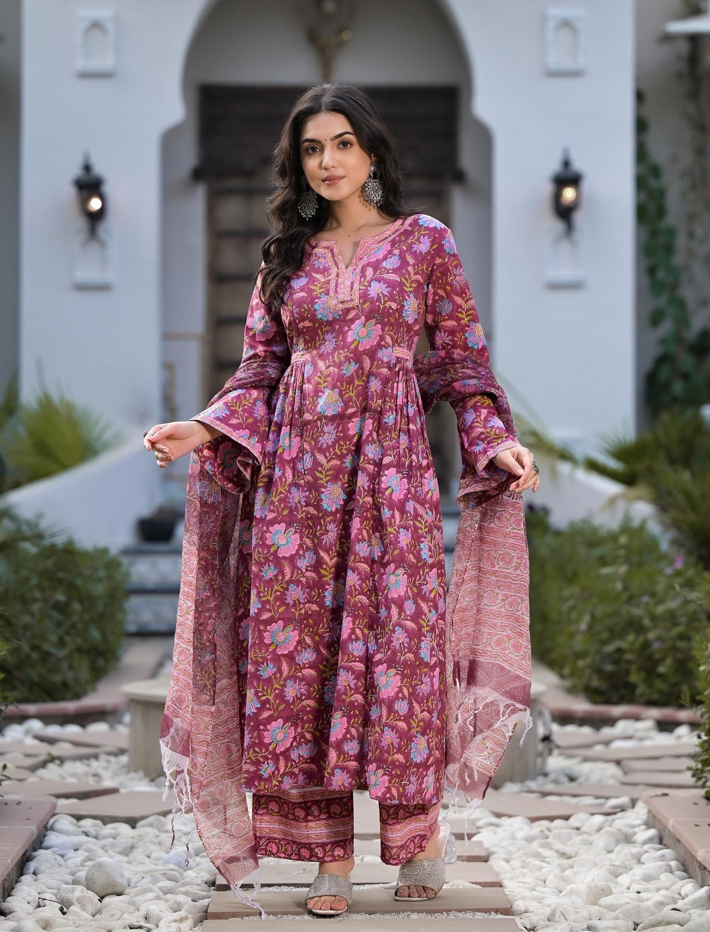 Woman in vibrant pink and purple floral printed cotton kurta set with sheer dupatta