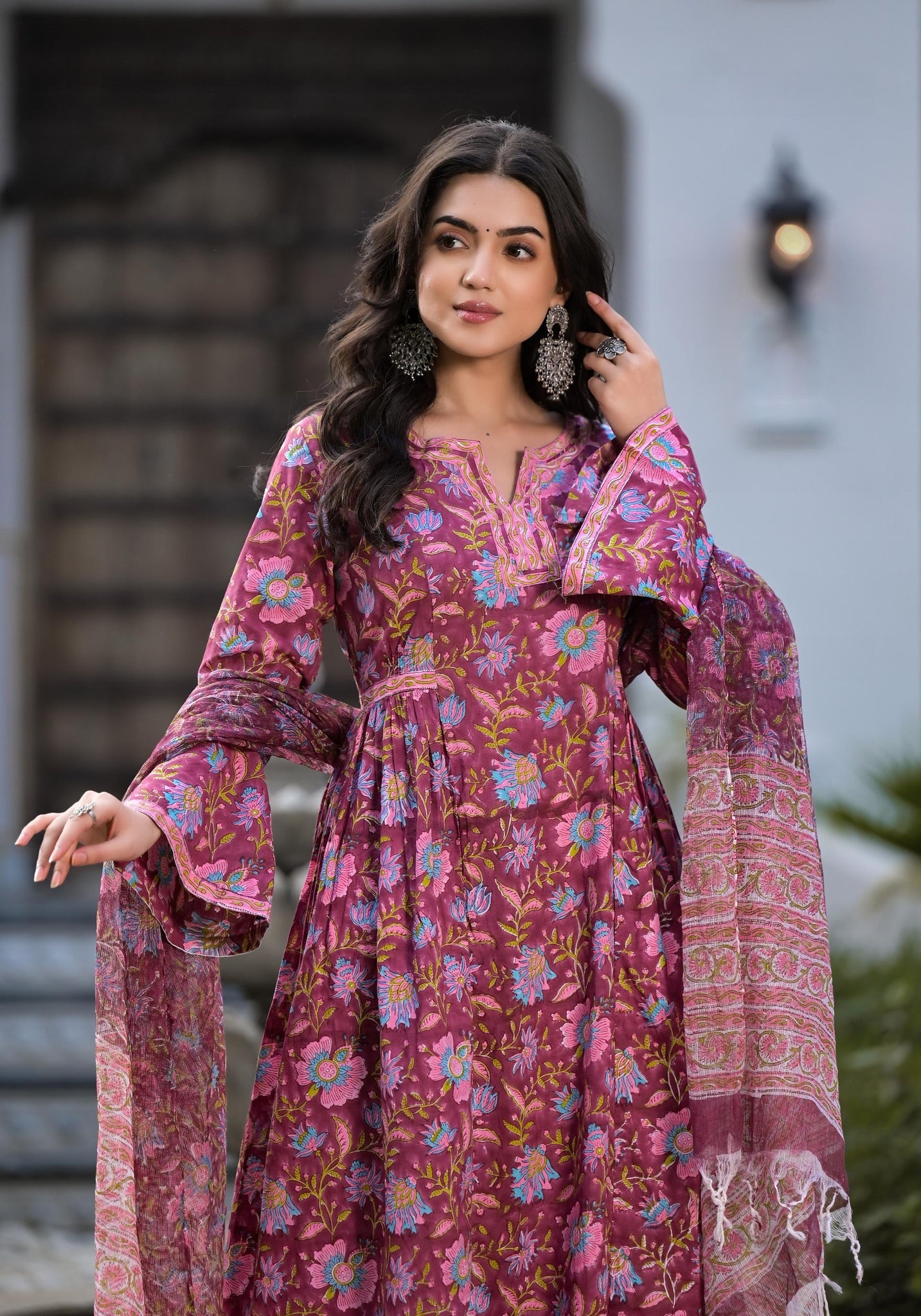 Woman in a vibrant Magenta Hand Block Floral Printed Cotton Kurta Set with flowing sleeves