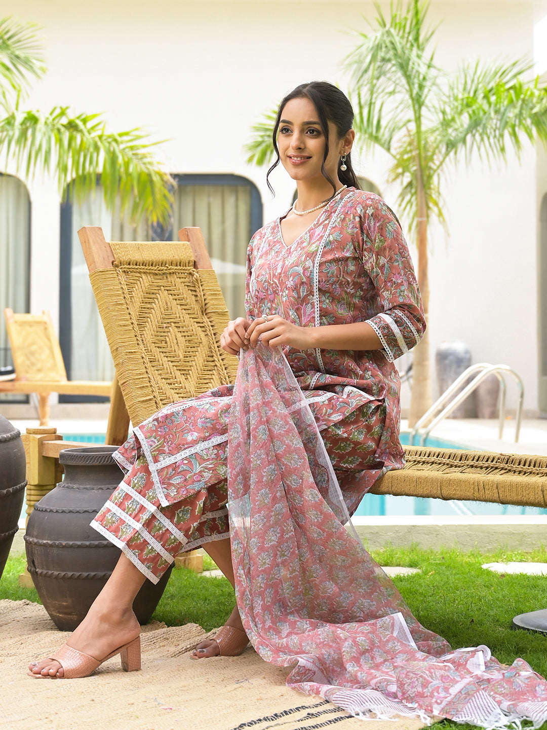 Woman in a pink floral sari seated on furniture next to Maroon Floral Print Cotton Handblock Kurta