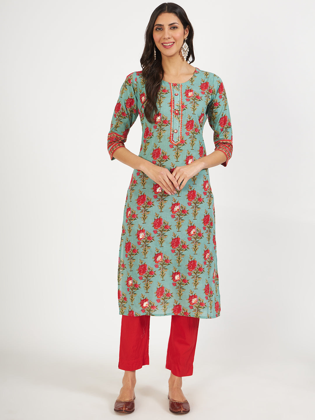 Woman wearing a Green Floral Print Cotton Kurta with red pants and brown sandals