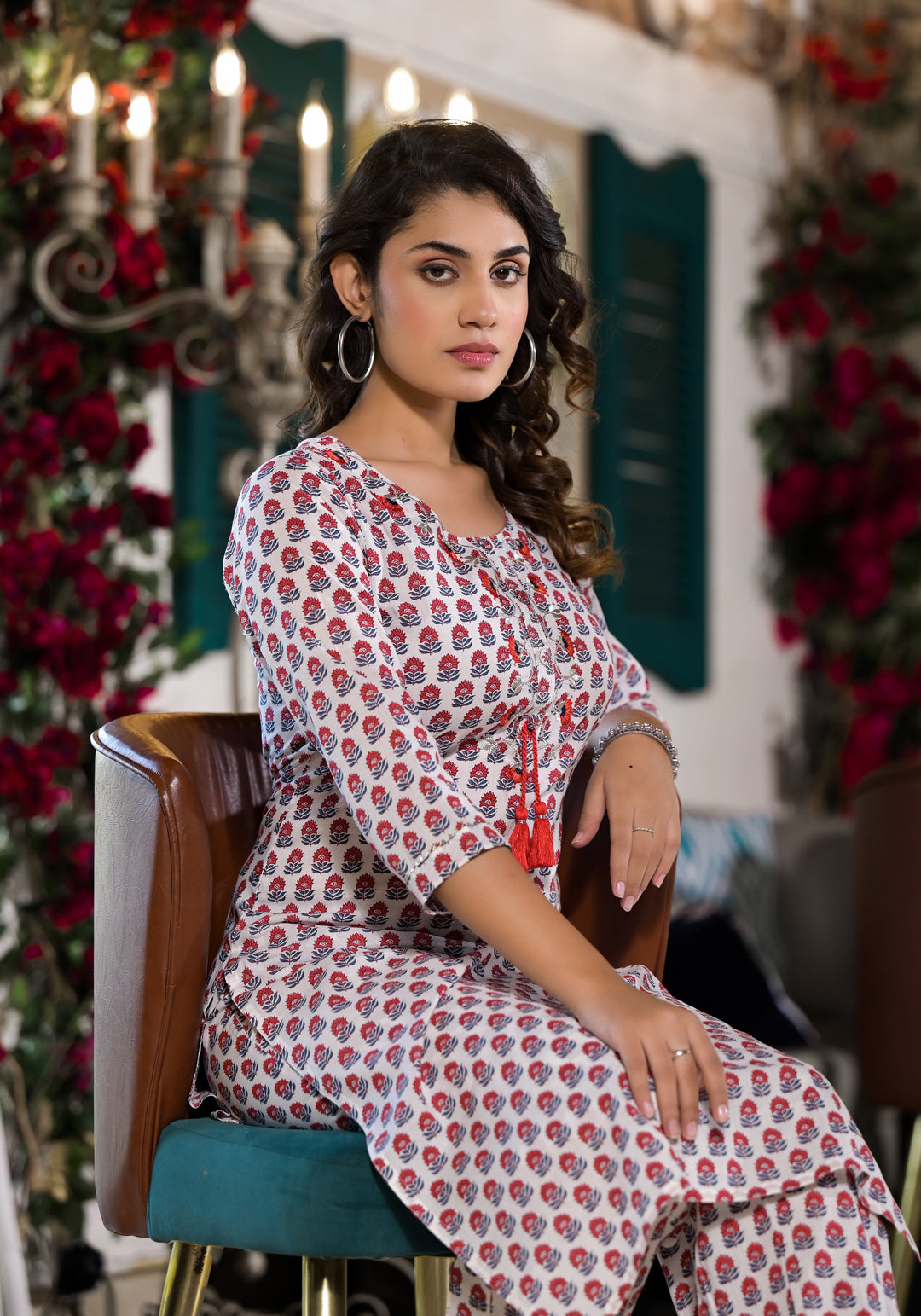 Woman in a red floral printed Kurta seated, showcasing Unicorn Fashion style