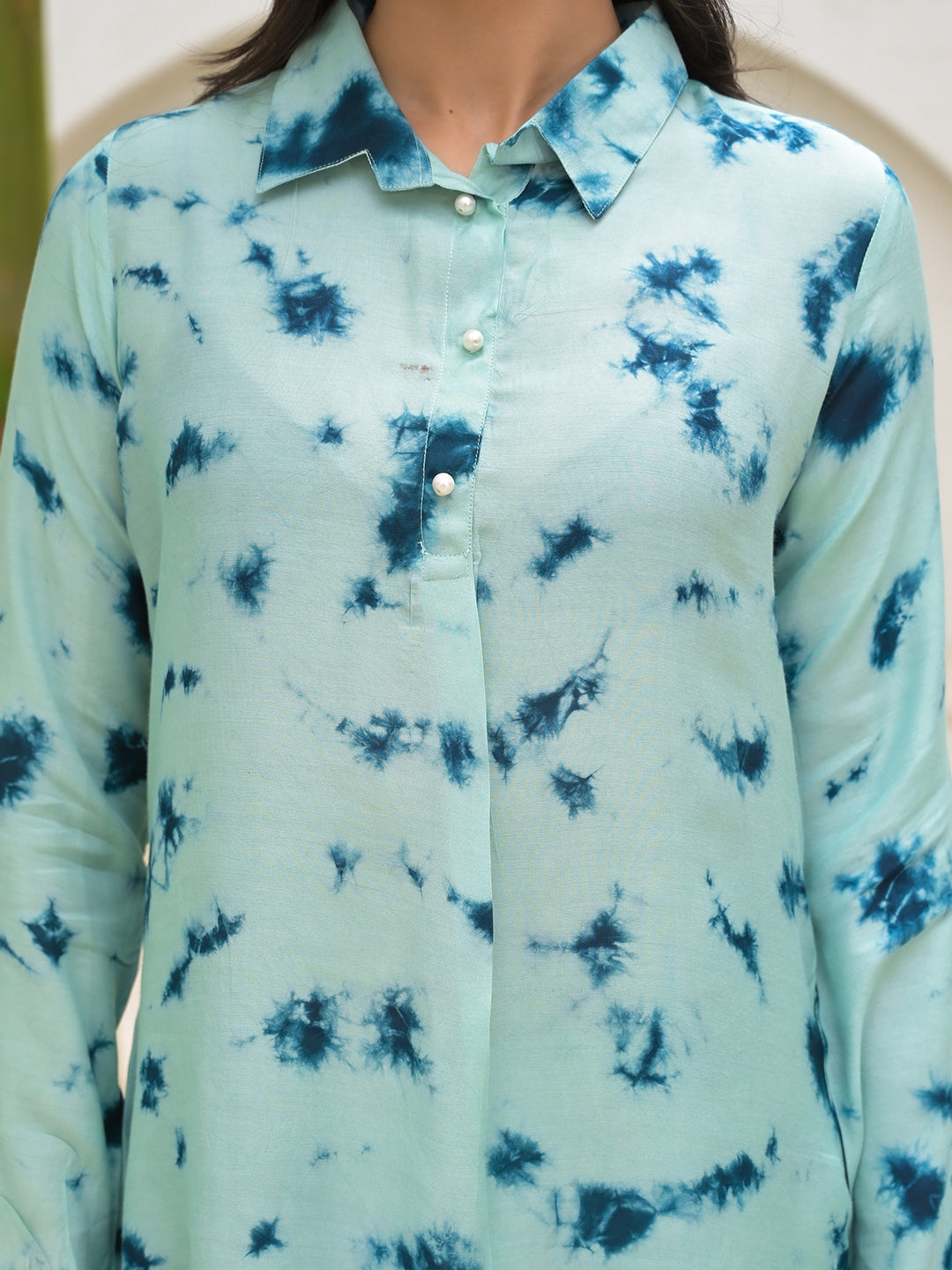 Tie-dye patterned button-up shirt in shades of light blue and navy.