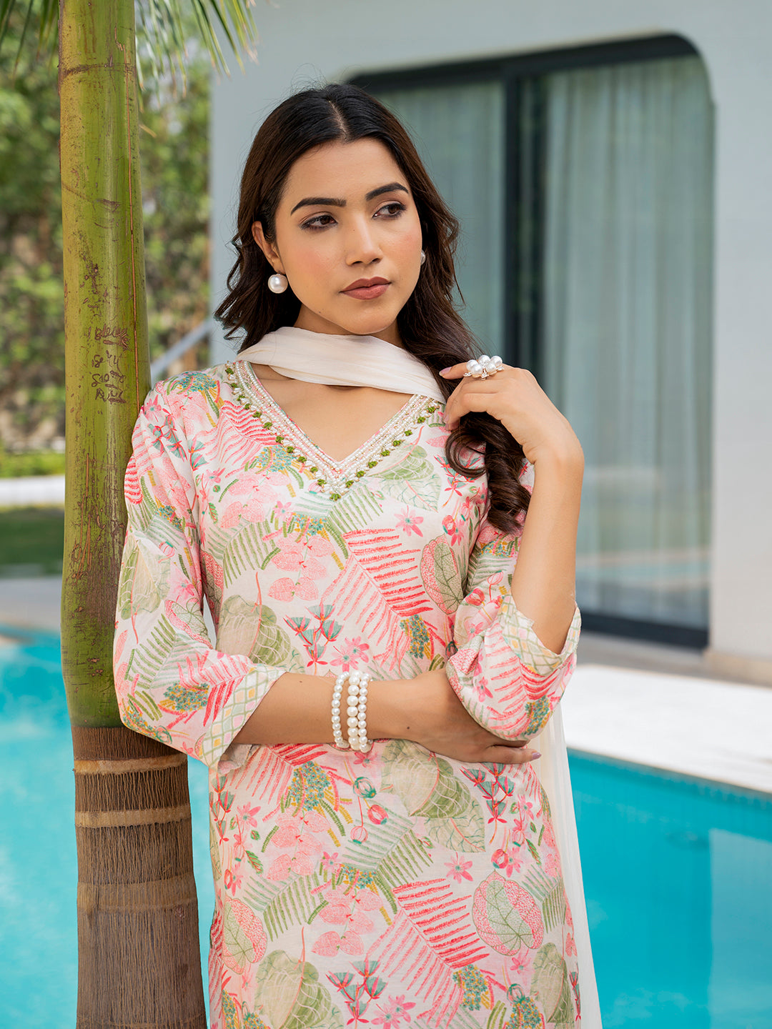 Woman in floral print muslin kurta set adorned with pearl accessories