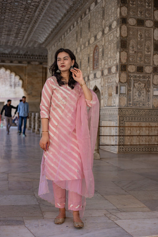 Woman in a light pink Leheriya cotton kurta with organza dupatta in an ornate hallway